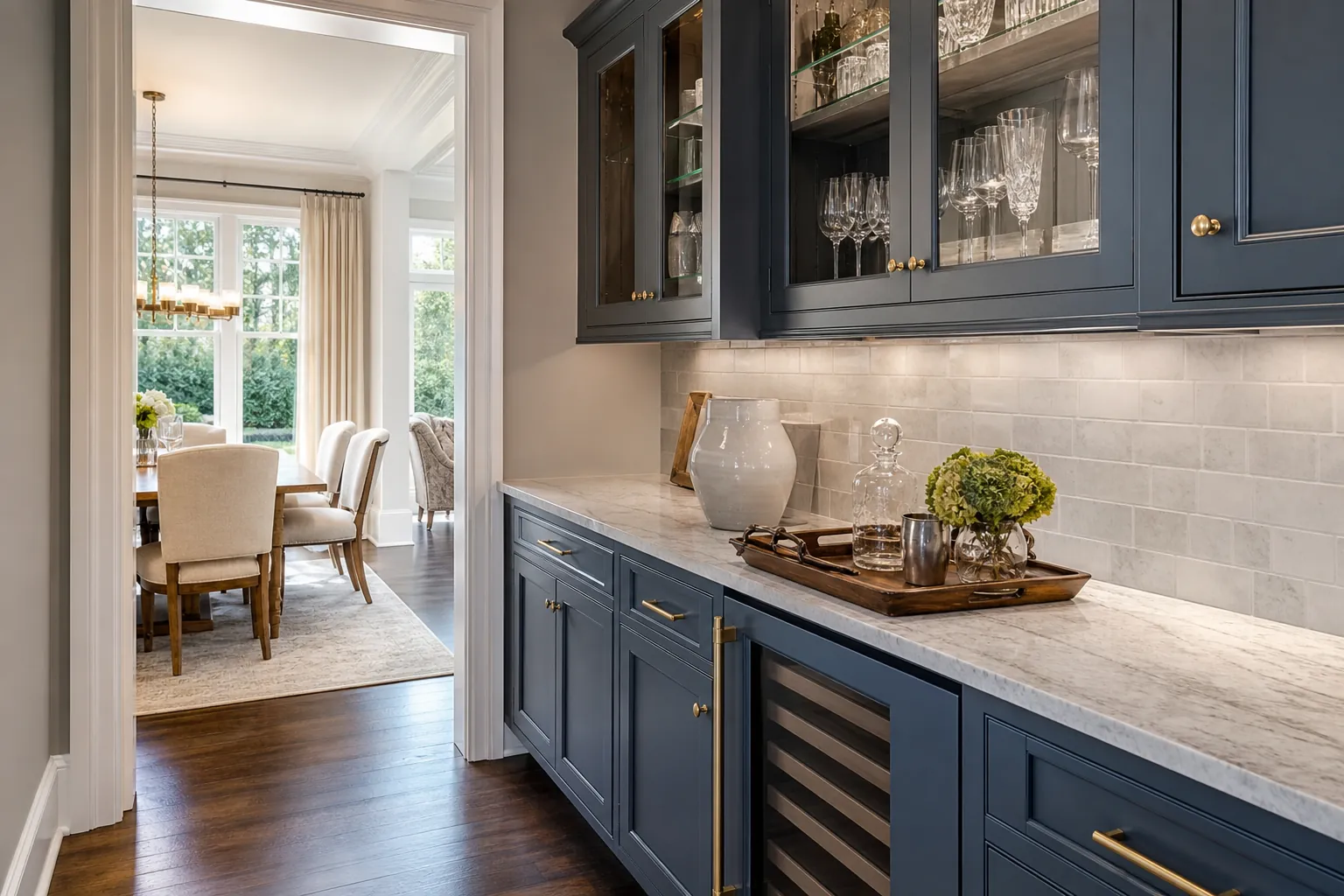 Navy Butler Pantry With Marble Counter and Wine Fridge Navy blue butler pantry with marble counters, glassware cabinets, wine fridge, and a doorway to the dining room