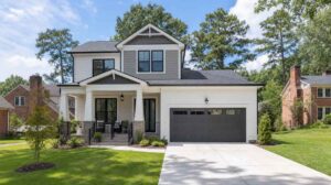 Blog | Cooper Development Group Newly completed two-story transitional craftsman spec home in Charlotte with gray and white lap siding, dark trim windows, covered front porch, and two-car garage